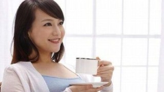 プーアル茶を飲みながら微笑む女性