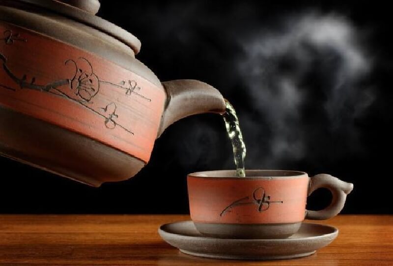 急須で中国茶を湯呑に煎れる